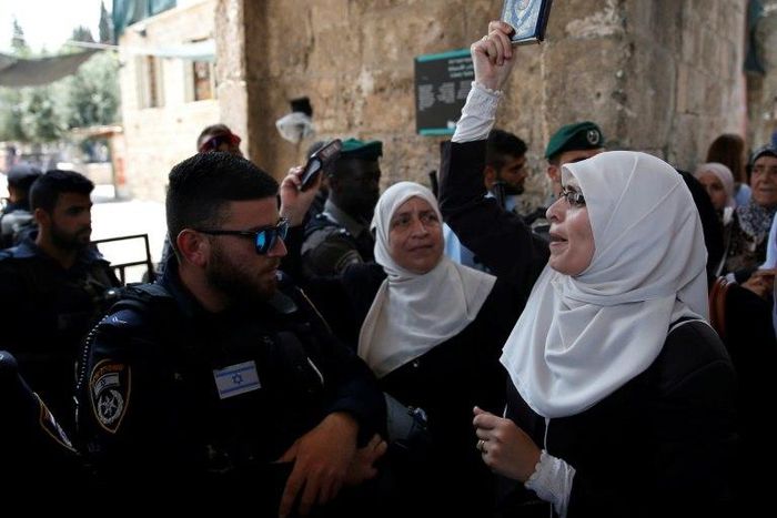 A Palestinian protester holds a copy of the Koran and shouts slogans in front of Israeli security forces during a demonstration in Jerusalem's Old City on July 20, 2017