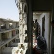 Members of the US-backed Syrian Democratic Forces move through destroyed buildings in Raqa on July 28, 2017