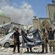 Iraqi soldiers pose with an upside-down flag of the Islamic State group outside the ruins of the Nuri mosque in the Old City of Mosul on June 30, 2017