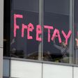 A makeshift sign goes up in an office window across from a courthouse where pop singer Taylor Swift is being sued for slander by a Denver DJ who she says groped her
