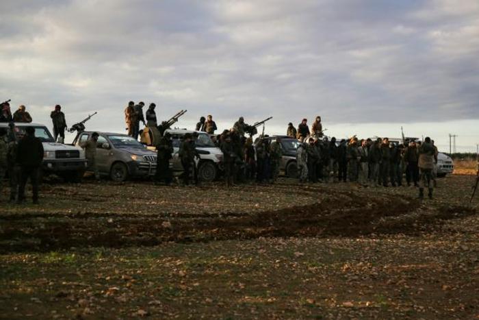 Turkish-backed Syrian fighters gather with their vehicles at a position near the northern Syrian town of Manbij, though the US military says it has seen no indication of the Syrian army entering the city