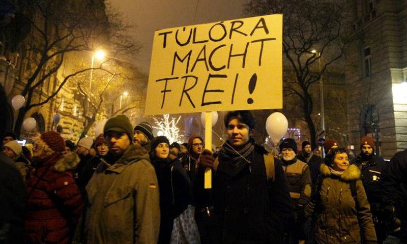 A protester holds a placard, reading 'Overtime sets you free' referring to the German phrase meaning "work sets you free" used at the entrance of the Auschwitz concentration camp, at a protest march against Hungary's new labour reform law