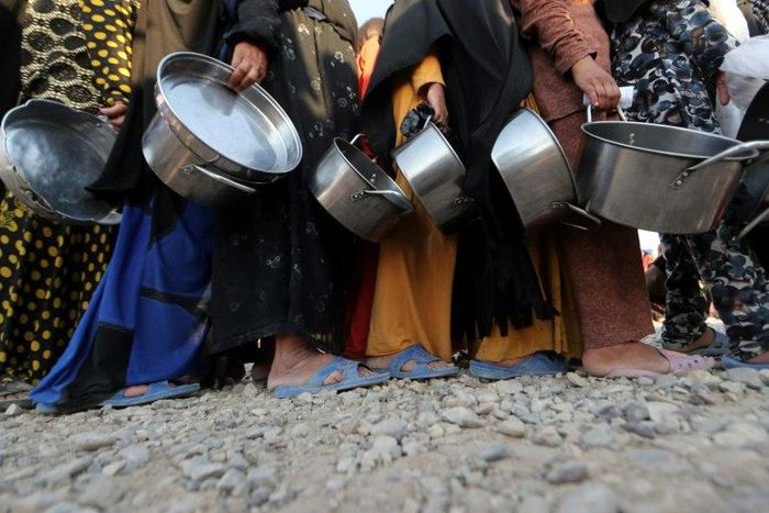 Displaced Iraqis receive aid food during the Muslim holy month of Ramadan at al-Khazir camp for the internally displaced, located between Arbil and Mosul, on June 5, 2017