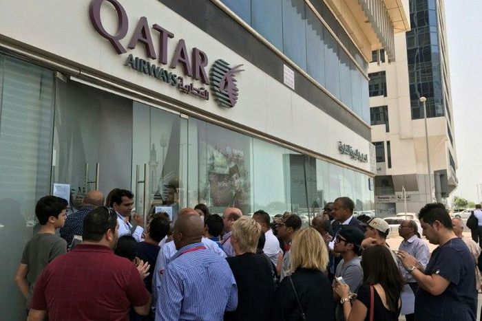 People gathered outside a branch of Qatar Airways in the Emirati capital of Abu Dhabi on Tuesday as travellers sought alternative travel plans because of bans on the airline