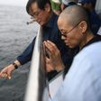 This handout photo provided by the Shenyang Municipal Information Office shows late Nobel laureate Liu Xiaobo's wife Liu Xia praying as they bury Liu's ashes at sea off the coast of Dalian, Liaoning Province, on July 15, 2017