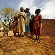Sudanese women and children stand next to a donkey in the war-torn town of Golo in the thickly forested mountainous area of Jebel Marra in central Darfur on June 19, 2017