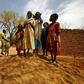 Sudanese women and children stand next to a donkey in the war-torn town of Golo in the thickly forested mountainous area of Jebel Marra in central Darfur on June 19, 2017