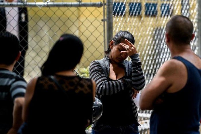 A relative of one of the victims of the club stampede waits outside the morgue in Caracas