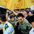Police and supporters surround a prison van transporting Joshua Wong after his sentencing