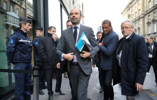 French Prime Minister Edouard Philippe (C) arrives to announce the suspension of fuel tax increases for six months after weeks of "yellow vest" popular protests