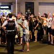 Tourists wait for the police to allow them to come back to their hotel on Las Ramblas boulevard after a van ploughed into the crowd, killing at least 13 people and injuring around 100 others on the Rambla in Barcelona, on August 18, 2017