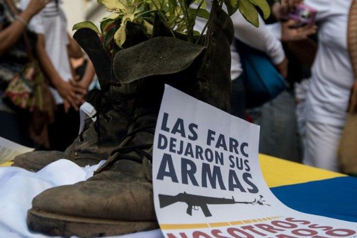 A Colombian FARC rebel turns his combat boots into a plant pot as a symbol of renouncing violence for peace, as up to 10,000 rebels prepare to return to civilian life