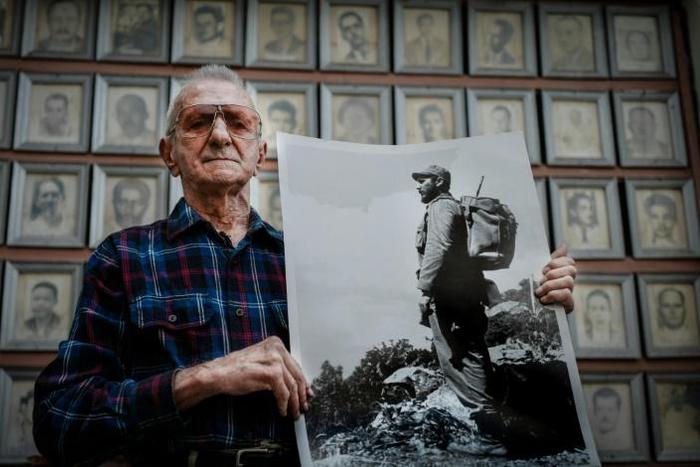 Cuban veteran Alejandro Ferras Pellicer poses with a picture of late leader Fidel Castro at his personal revolution museum in Havana