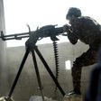 A fighter of the US-backed Syrian Democratic Forces fires a machine gun during their advance into the Islamic State group stronghold of Raqa on June 21, 2017
