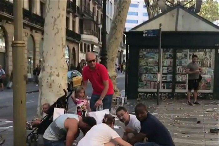 This video grab obtained from the instagram account carlos_tg_32_ shows people tending to an injured woman after a van ploughed into the crowd on Barcelona's popular Las Ramblas boulevard.