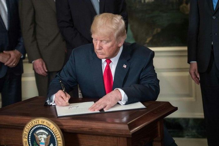 US President Donald Trump signs a memorandum on addressing China’s laws, policies, practices, and actions related to intellectual property, innovation, and technology at the White House in Washington, DC, on August 14