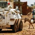 A Sudanese boy rides a donkey past an armoured vehicle of a UN-African Union mission in the war-torn town of Golo in central Darfur on June 19, 2017