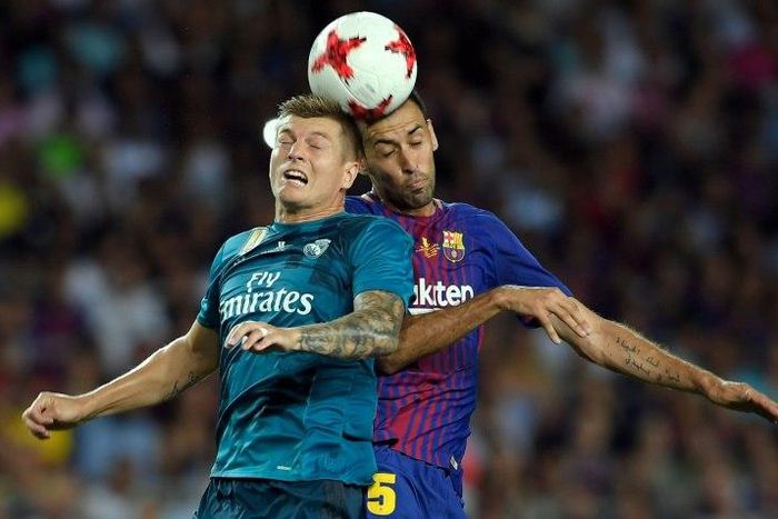 Barcelona's Sergio Busquets (R) fights for the ball with Real Madrid's Toni Kroos during their Spanish Super Cup first leg match, at Camp Nou in Barcelona, on August 13, 2017