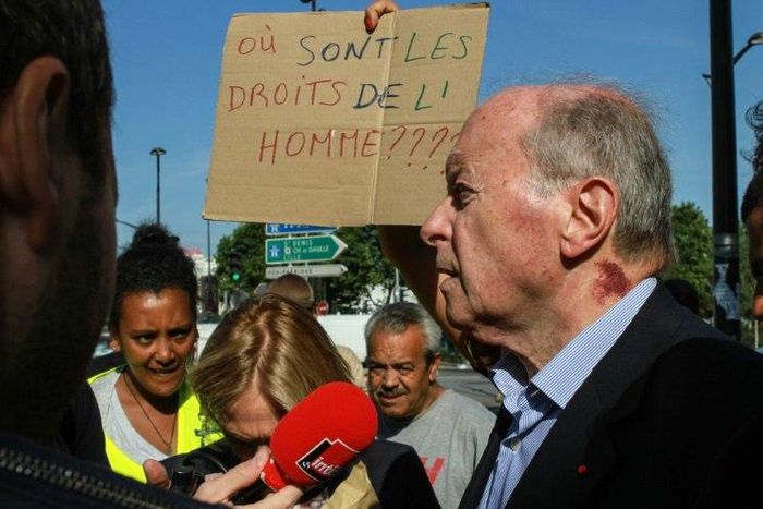 French rights watchdog head Jacques Toubon speaks with migrants during a visit to a humanitarian reception centre for migrants in Paris on Friday.