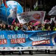 Demonstrators march behind an anti G-20 banner during a demonstration called by several NGOs ahead of the G20 summit in Hamburg on July 2, 2017