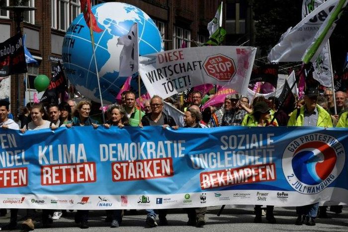 Demonstrators march behind an anti G-20 banner during a demonstration called by several NGOs ahead of the G20 summit in Hamburg on July 2, 2017