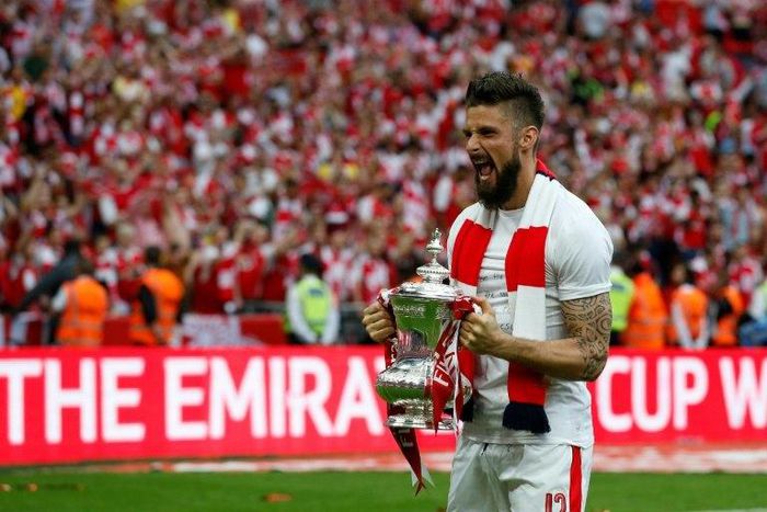 Arsenal's striker Olivier Giroud celebrates with the FA Cup trophy as Arsenal players celebrate their victory over Chelsea on the pitch after the English FA Cup final football match May 27, 2017