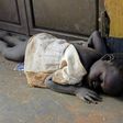 A newly arrived refugee child from South Sudan sleeps on a dirty floor on the Ugandan side of the Ngomoromo border post