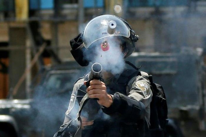 An Israeli border guard fires tear gas at Palestinian protesters near the Jewish settlement of Beit El in the occupied West Bank on July 24, 2017