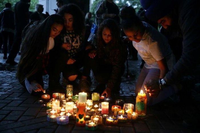 People light candles after a silent march in memory of the victims of the Grenfell Tower fire