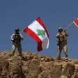 A handout picture released by the Lebanese army on August 19, 2017, shows Lebanese soldiers holding up the Lebanese and Spanish flags in Jurud Ras Baalbek, in solidarity with Spain after twin attacks claimed by the Islamic State group