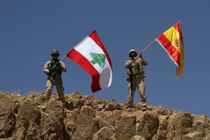 A handout picture released by the Lebanese army on August 19, 2017, shows Lebanese soldiers holding up the Lebanese and Spanish flags in Jurud Ras Baalbek, in solidarity with Spain after twin attacks claimed by the Islamic State group