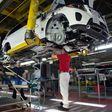 An employee installs parts on the undercarriage of a Mercedes-Benz GLS-Class SUV at the Mercedes-Benz US International factory in Vance, Alabama on June 8, 2017.