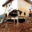 An excavator clears mud and debris after the partial collapse of a hillside in Freetown, Sierra Leone, that swept away hundreds of homes