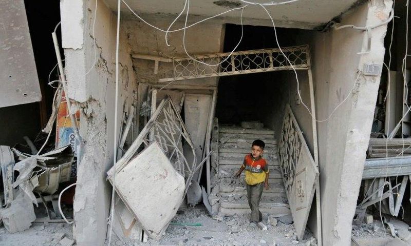 A Syrian child walks out of damaged building following an air strike on the rebel-held town of Arbin, east of the capital, on July 22.