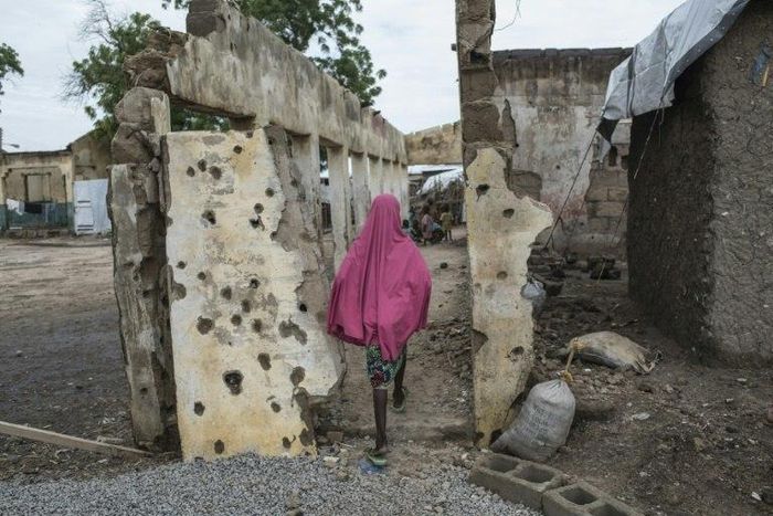 A girl walks through an area where a Nigerian fighter jet mistakenly bombed civilians in January