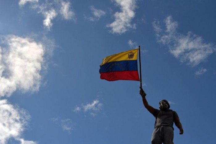 An opposition demonstrator holds a national flag during the "Towards Victory" protest against the government of Nicolas Maduro, in Caracas on June 10, 2017