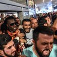 French forward Bafetimbi Gomis (centre) is escorted outside the Ataturk International airport as he is greeted by fans upon his arrival, on June 28, 2017 in Istanbul