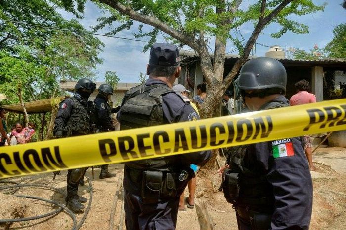 Police stand outside the house where were six people, including a four-month-old baby, were killed by gunmen in San Pedro Cacahuatepec, Acapulco municipality, Mexico's Guerrero state, on June 9, 2017