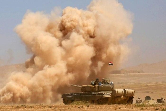 Smoke billows as Iraqi government forces supported by fighters from the Abbas Brigade, which fights under the umbrella of the Shiite popular mobilisation units, advance towards the city of Tal Afar