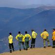 Members of a fire brigade stand on a cliff after extinguishing a wildfire near the village of Santa Eugenia, northern Portugal's Alijo municipality, on July 18, 2017