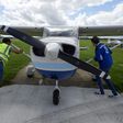 Pilot Somasekhara Pemmireddy (L) and passenger Adam Nicholas park the plane after a flight over the capital in a Cessna 172 plane, at the London North Weald airfield on August 1
