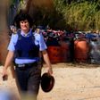 A policewoman walks with dozen of gas bottles in the background in Alcanar, during a search linked to the Barcelona and Cambrils attacks