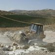 A worker uses a bulldozer to clear the land for the new Amichai settlement, between Ramallah and Nablus in the West Bank, on June 20, 2017