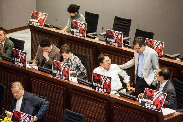 Pro-democracy lawmakers display signs reading "ceding land with co-location puts Hong Kong in danger" during a meeting to discuss the high-speed rail link