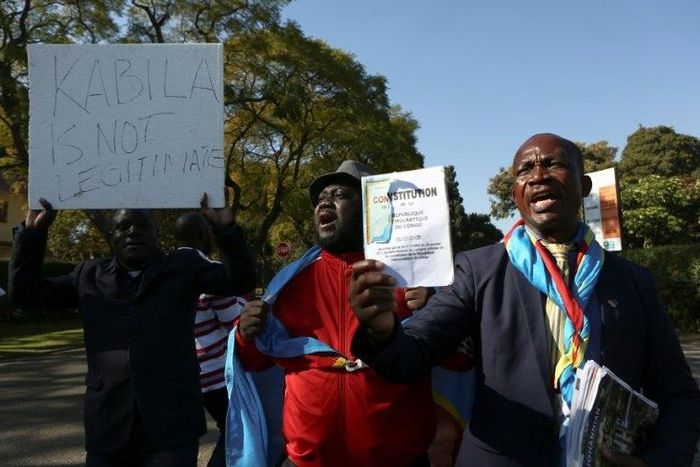 Anti-President Kabila protestors shout slogans and wave placards as they demonstrate near the entrance to a presidential guest house in Pretoria on June 24, 2017, where the President of the Democratic Republic of Congo Joseph Kabila and South African p...