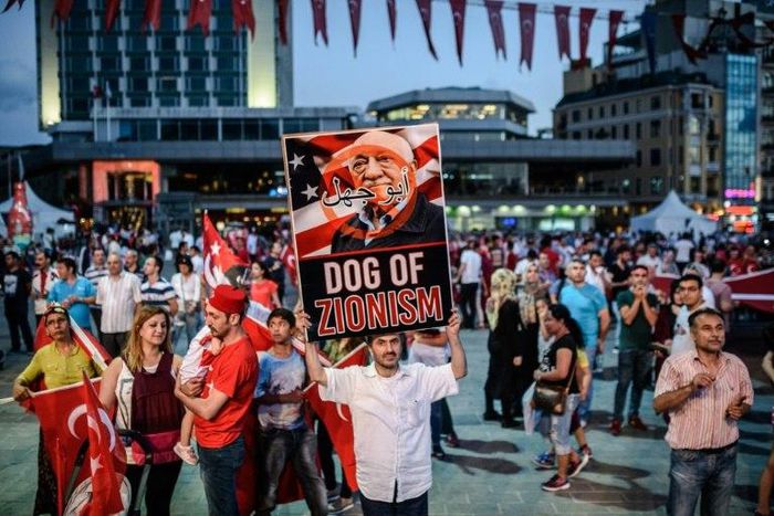 A pro-Erdogan supporter holds a portrait of US-based cleric Fethullah Gulen during a rally against the military coup in Istanbul on July 25, 2016