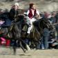 A Kyrgyz man rides to catch a woman wearing a traditional bridal gown during a folk festival