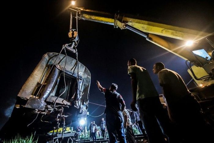 Emergency personnel lift a carriage with a crane following a collision between two trains on August 11, 2017 near the Mediterranean city of Alexandria that killed at least 40 people