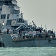 The guided-missile destroyer USS John S. McCain, with a hole on its portside after a collision with an oil tanker, makes its way to Changi naval base in Singapore
