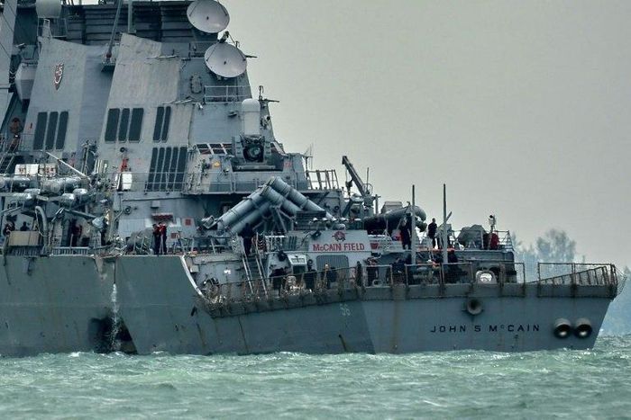 The guided-missile destroyer USS John S. McCain, with a hole on its portside after a collision with an oil tanker, makes its way to Changi naval base in Singapore